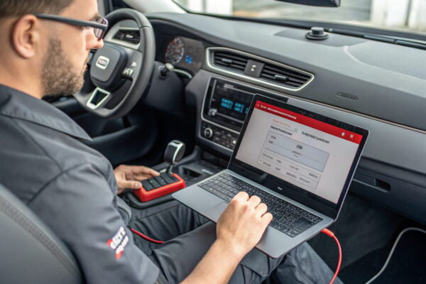 KFZ-Steuergerät auslesen: Häufige Probleme und Lösungen Person behebt ein Verbindungsproblem beim Auslesen des KFZ-Steuergeräts mit einem OBD2-Adapter.